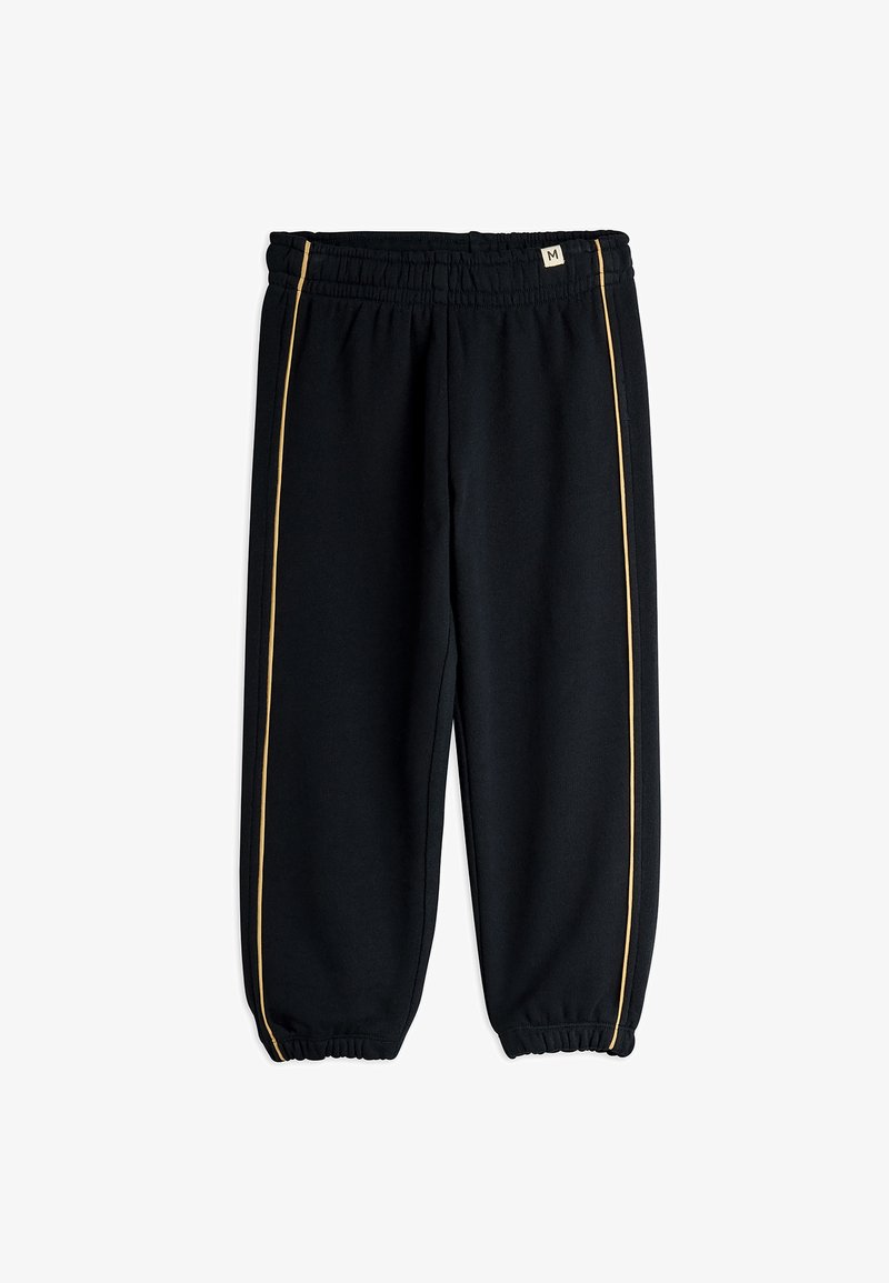 Čierne tepláky s elastickým pásom a manžetami, ktoré majú tenké žlté pruhy bežiace vertikálne po vonkajších stranách každej nohy.