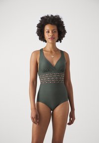 Maillot de bain une pièce vert avec un décolleté en V profond, de larges bretelles et une bande texturée à motif léopard à la taille. Finition en tissu lisse.