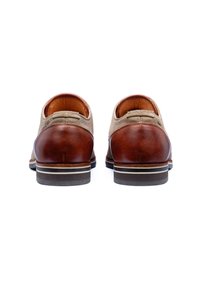 Bruine leren schoenen met een beige suède bovenkant, een ronde hak, een wit en zwart gestreepte zool en gestikte accenten aan de achterkant.