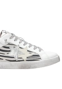 Sneaker bianco con accenti di stelle argento e beige, motivo a strisce zebra e lacci luccicanti. Suola in gomma testurizzata.