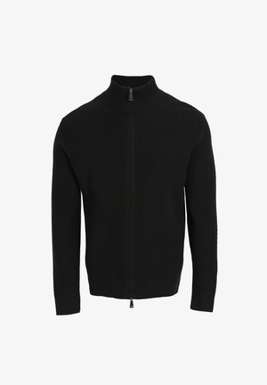 Pull zippé noir à côtes avec col montant, doté de manches longues et d'une fermeture éclair lisse à l'avant. Design simple et matériau texturé.
