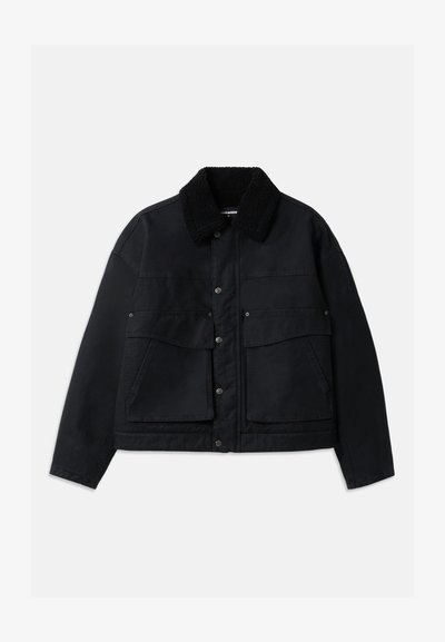 Black jacket with a textured, black shearling collar. Features front button closure and two large chest pockets. Material appears sturdy.