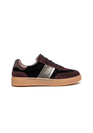 Zapatilla baja con terciopelo negro, superposiciones de ante marrón oscuro, rayas metálicas plateadas, cordones negros y suela de goma, mostrada de lado.