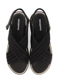 Svarta sandaler med korskorsade remmar av mjukt material, med en vadderad inläggssula och en ljusfärgad sula. Varumärket synligt.