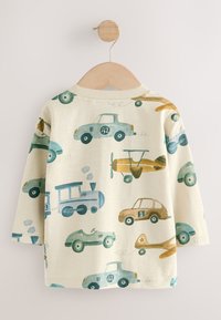 Bawełniana koszula z długim rękawem, ozdobiona wesołym nadrukiem samochodów i samolotów w odcieniach niebieskiego, brązowego i zielonego na kremowym tle.