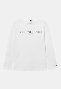 Langärmliges, weißes Baumwoll-T-Shirt mit einem marineblauen Logo-Druck "TOMMY HILFIGER EST. 1985" über der Brust und einem kleinen Logo am Bund.