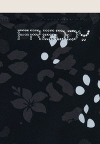 Musta kangas, jossa on harmaita ja valkoisia kukka- ja abstraktikuvioita. "Freddy"-logo, joka on koristeltu kaunistuskivillä, ylhäällä.