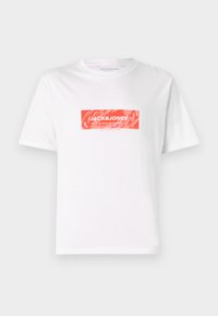 Hvid bomulds t-shirt med et rødt rektangulært logo designet centreret på forsiden med teksten "JACK&JONES" og abstrakte mønstre.