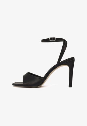 Sandalo nero con tacco alto, punta aperta, fascia frontale larga singola, sottile cinturino alla caviglia con fibbia argento e tacco a spillo sottile.