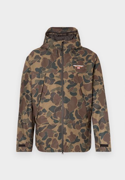 Vīriešu kapučveida jaka ar kamuflāžas rakstu, pilna priekšējā rāvējslēdzēja, regulējamiem aproču galiem un "Polo Sport Ralph Lauren" logotipu kreisajā krūšu daļā.