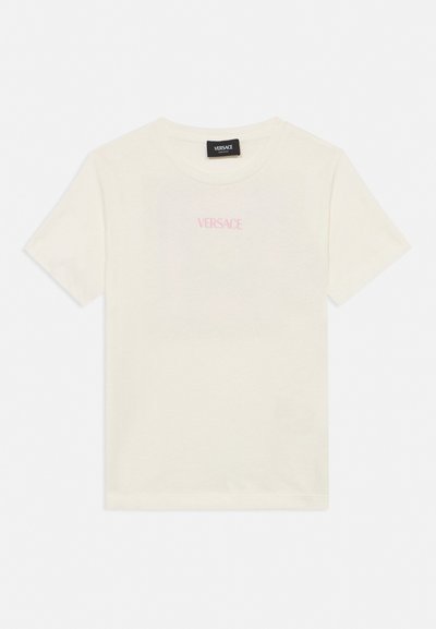 Λευκό T-shirt Versace με κοντά μανίκια και στρογγυλή λαιμόκοψη με διακριτικό ροζ λογότυπο τυπωμένο στο στήθος, παρουσιασμένο σε λευκό επίπεδο φόντο.