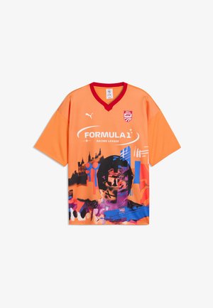 Pomarańczowa koszulka Orange Puma Formula 1 Racing League z czerwonym kołnierzem i abstrakcyjną grafiką kierowcy w kasku i panoramą miasta z przodu.