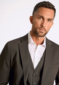 Donkergrijs colbert met een notch lapel, gecombineerd met een wit overhemd. De ensemble heeft een vest en zwarte knopen op het colbert.