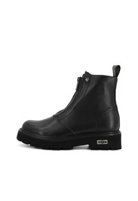 Stivali alla caviglia in pelle nera con zip laterale, suola piatta e accenti testurizzati. Dotati di un linguetta per una facile indossabilità.