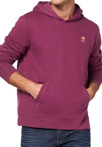 Fioletowy bawełniany sweatshirt z kangurzą kieszenią, prążkowanymi mankietami i małym logo na piersi. Gładka tekstura z luźnym krojem.