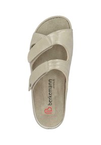 Light beige slide sandal with two crossover straps, made of textured material. Soft insole with logo printed. Smooth upper surface, open toe design.