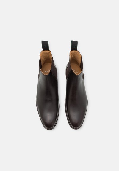 Brune lær chelsea støvler med en glat overflade, elastiske sidepaneler og trækflapper. Rund tå og slank således design.