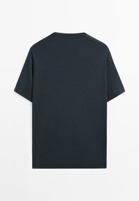 T-shirt nera a maniche corte in cotone vista da dietro con scollatura a girocollo su sfondo bianco.