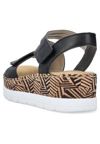 Schwarze Sandalen mit einer Korkmuster-Wedgesohle. Sie verfügen über einen Klettverschluss und ein glattes Leder-Obermaterial, das ein strukturiertes, geschichtetes Design bietet.