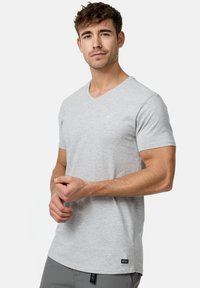 Grijze v-hals t-shirt van een katoenmix. Korte mouwen, slim fit en een klein logo-detail op de borst. Etiket zichtbaar aan de onderkant.