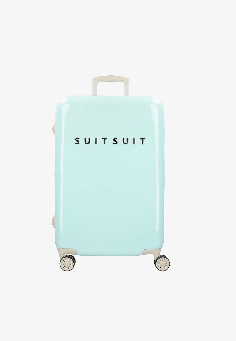 Harde koffer in pastelblauw, met een textuurafwerking, beige handvat en vier wielen. De merknaam "SUIT SUIT" is centraal op de voorkant geplaatst.