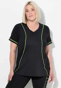 Camiseta atlética negra de manga corta, con escote en V y costuras acentuadas en verde. Hecha de un tejido ligero y transpirable.