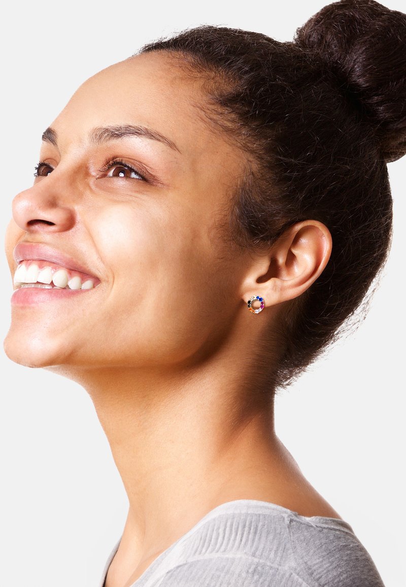 Guldörhängen med en färgglad ädelstenkluster, som har blå, orange och svarta stenar, i en cirkulär design.