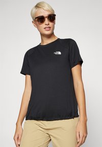 Črna kratka športna majica s kratkimi rokavi in okroglo ovratnico, na levi prsni strani z logotipom The North Face. Gladek material, sproščen kroj, lahek dizajn.