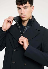 Zwart mannen dubbelgebreide jas met een gestructureerde kraag, grote knopen en een rits-insteek. Soepele stof met een getailleerde pasvorm.