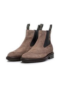 Botas de tobillo de ante marrón con paneles elásticos en los lados, detalles decorativos de brogue y una resistente suela de goma negra. Lengüetas dobles para un fácil calce.