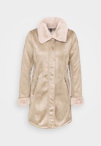 Abrigo beige forrado de piel sintética con cuello mullido, mangas largas y bolsillos laterales con cremallera; textura suave y diseño hasta la rodilla.