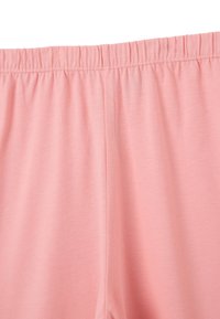 Tissu en coton rose clair avec un waistband élastique et une texture lisse. Présente un design simple sans motifs ni accents visibles.