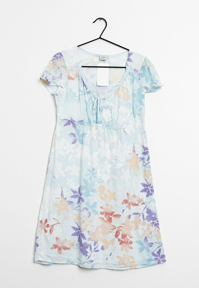 Robe à manches courtes bleu clair avec imprimé floral multicolore et lien à l'encolure dégagée, suspendue sur un cintre noir sur fond blanc.