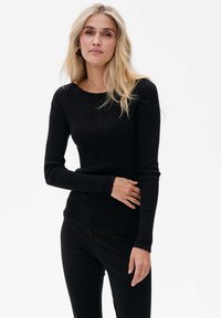 Schwarzer gerippter Strickpullover mit langen Ärmeln, rundem Ausschnitt und taillierter Silhouette. Glatte Textur und dezenter Stretch.