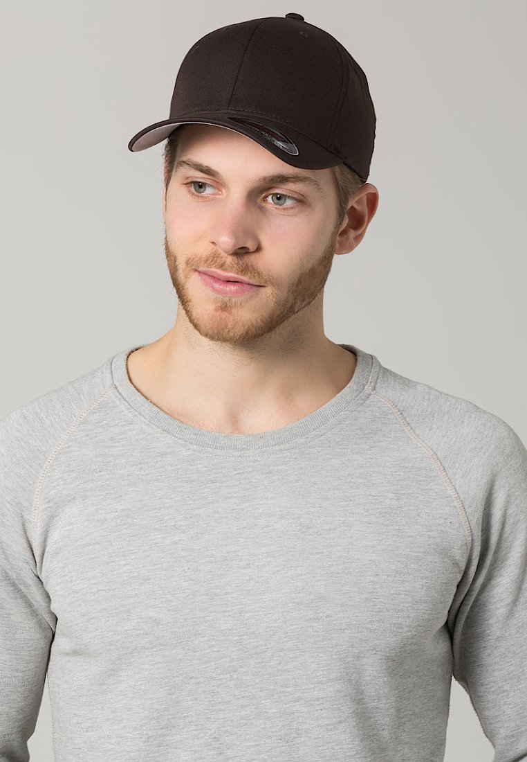 Zwarte baseballpet met een glanzende klep, gedragen met een lichtgrijs T-shirt met lange mouwen, dat een ronde halslijn en raglan mouwontwerp heeft.