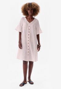 Gestreepte blousejurk met een V-hals, uitlopende korte mouwen en houten knopen. De stof is lichtgewicht met een zachte textuur.