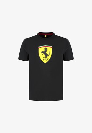 Czarna koszulka z krótkim rękawem wykonana z bawełny, z żółtym logo tarczy Ferrari przedstawiającym skaczącego konia oraz paskami w kolorach zielonym, białym i czerwonym.