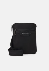 Černá nylonová crossbody taška s horním zipovým uzavřením, přední zipovou kapsou a nastavitelným popruhem s embosovaným logem. Texturovaný povrch.
