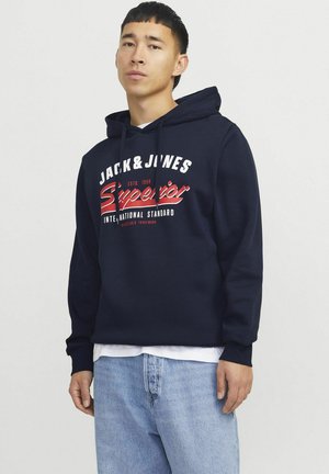 Felpa blu navy in pile, con un logo grafico bianco e rosso sul fronte. Dotata di cappuccio con cordino e tasca a marsupio.