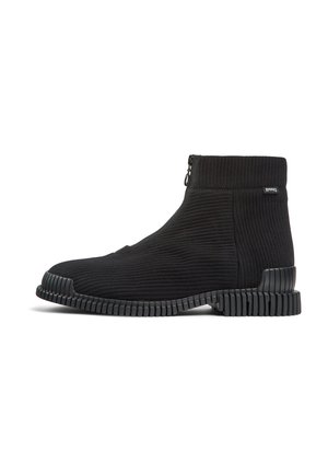 Botines negros de tobillo con parte superior de textil acanalado, cierre lateral con cremallera y suela de goma texturizada con ranuras horizontales.