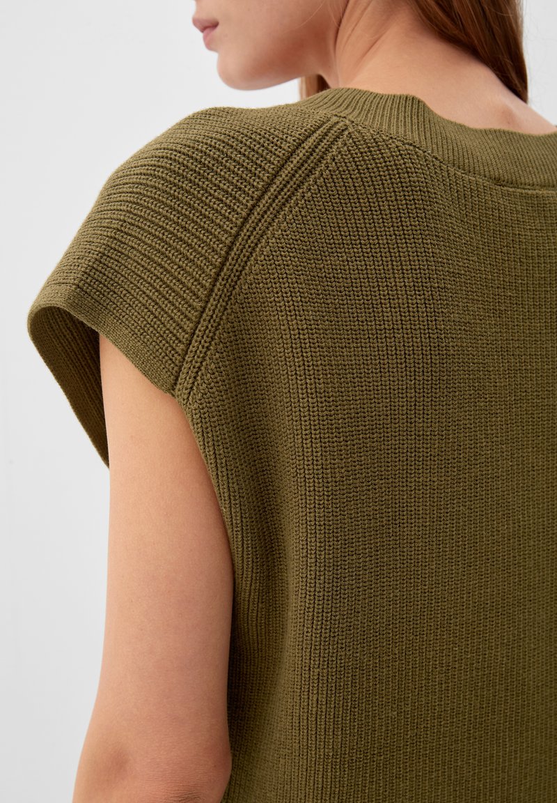 Übergroßer olivgrüner Strickpullover mit strukturiertem Muster, ausgestattet mit kurzen Ärmeln und einem Rundhalsausschnitt.
