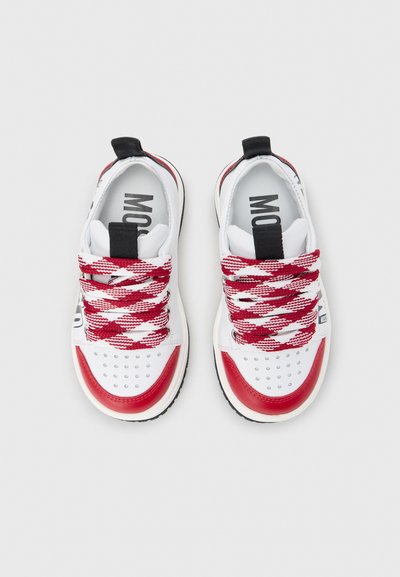 Άσπρα αθλητικά παπούτσια με κόκκινες λεπτομέρειες και υφή στη μύτη. Διαθέτουν κορδόνια με κόκκινο και λευκό μοτίβο. Μαύρη ταπεινή γλώσσα και λογότυπο στο εσωτερικό.