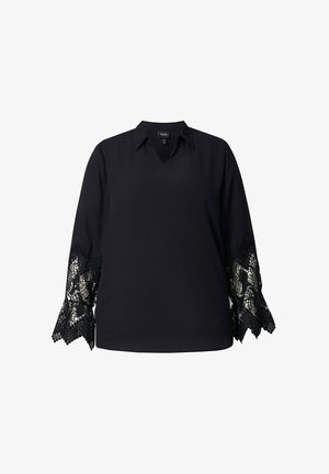 Blusa negra con cuello en V y mangas largas. Las mangas presentan un intrincado borde de encaje negro con bordes ondulados. Textura suave.