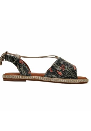 Patterned sandal with a dark floral design, open sides, and a knotted back strap. Features a textured sole with a woven accent.
