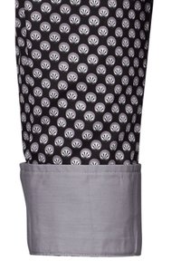 Tessuto nero con motivi a conchiglia bianchi e grigi che si ripetono, con un polsino grigio nella parte inferiore. Texture liscia, vestibilità sartoriale.