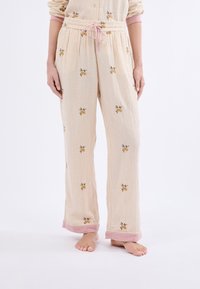 Lichtbeige pyjamabroek met verticale strepen, bloemembroidery en roze manchetaccenten; elastische tailleband met verstelbare trekkoord.
