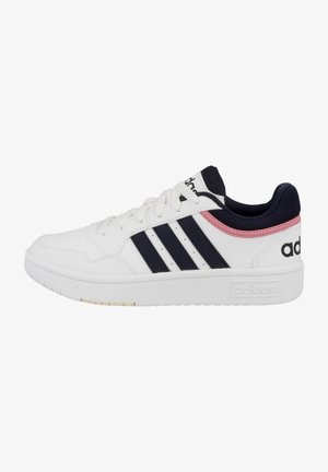 Sneaker bianco con tre strisce navy e un accento rosa sul tallone. Presenta una tomaia sintetica, suola in gomma e chiusura con lacci.