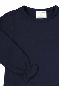 Marinblå långärmad topp med rund hals, rynkad detalj vid handleden, tillverkad av mjuk bomull, med en etikett som visar märke och storleksinformation.