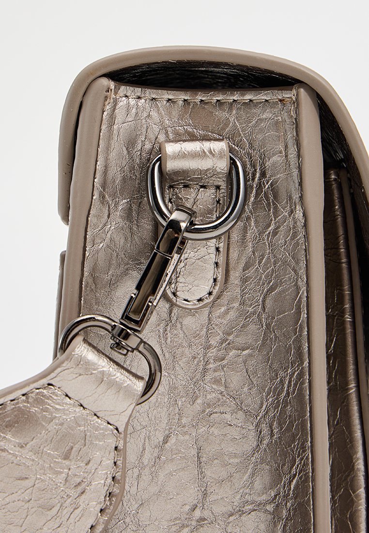 Metallisch silberne Handtasche mit strukturierter Oberfläche. Verfügt über einen silbernen Verschluss und Akzente, die ihr elegantes, modernes Design betonen.