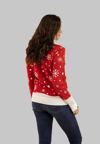 Roter Pullover mit weißen Schneeflocken und Punkten, mit einem gerippten weißen Saum und Bündchen, aus Strickstoff gefertigt. Rückansicht dargestellt.